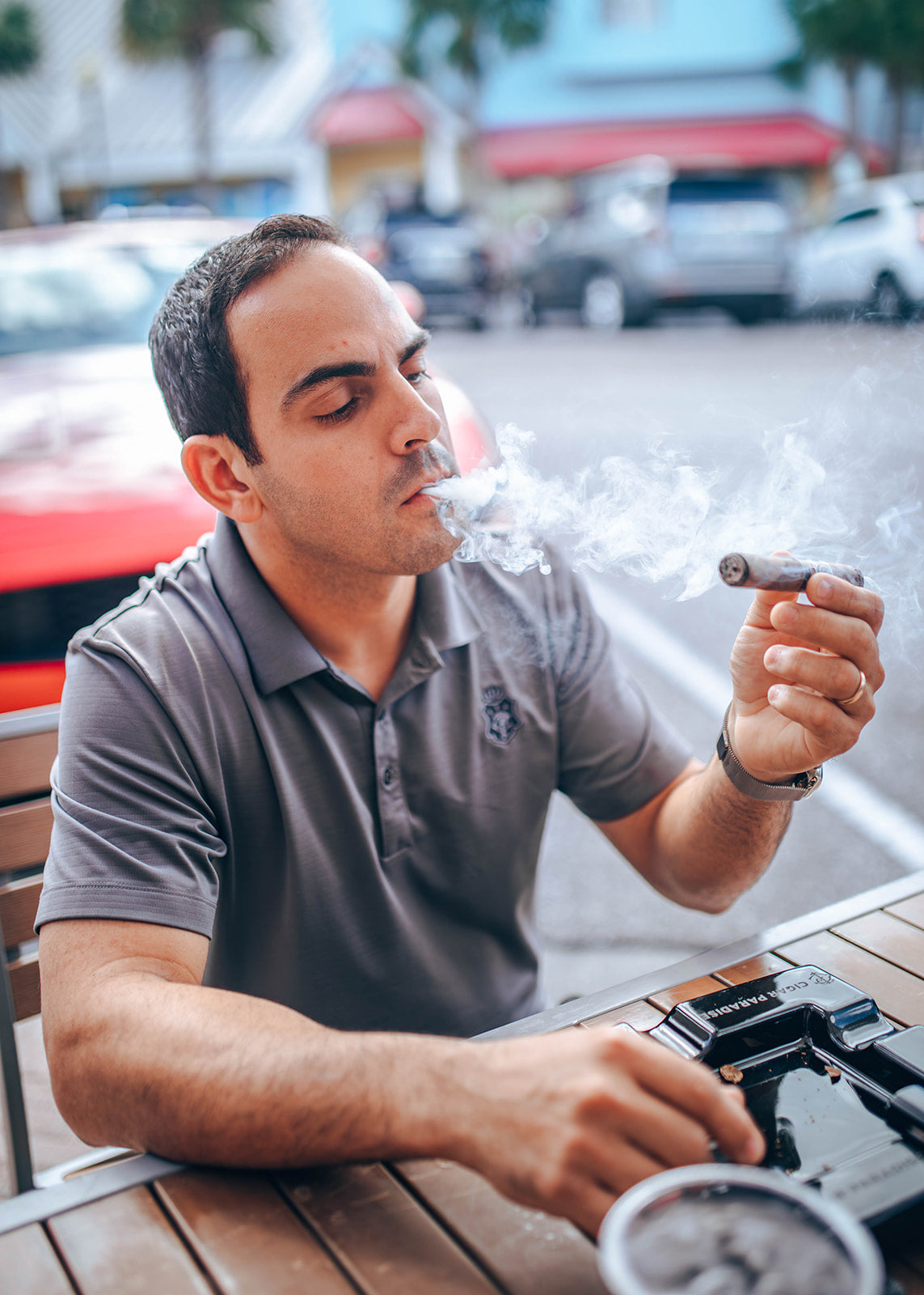Cigar Paradise staff member enjoying a cigar while seated outdoors